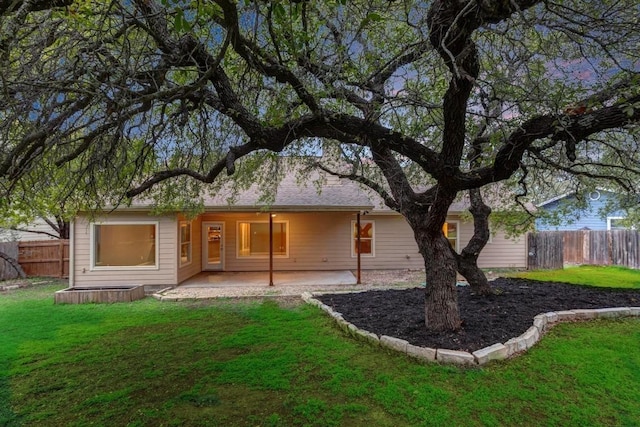 rear view of house with a patio and a lawn