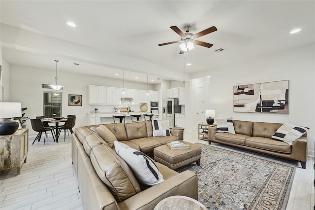 living room featuring light hardwood / wood-style flooring and ceiling fan