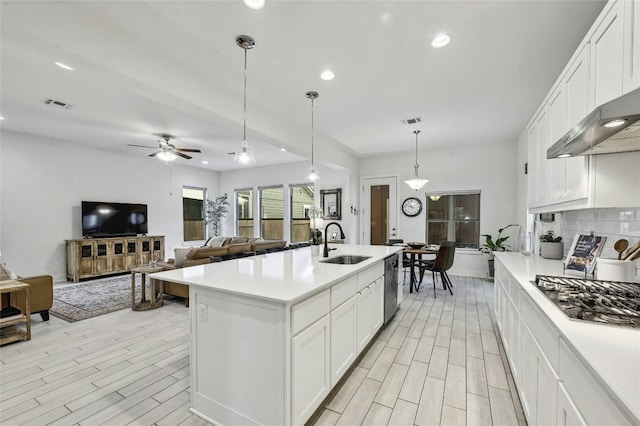 kitchen with white cabinetry, appliances with stainless steel finishes, sink, and hanging light fixtures