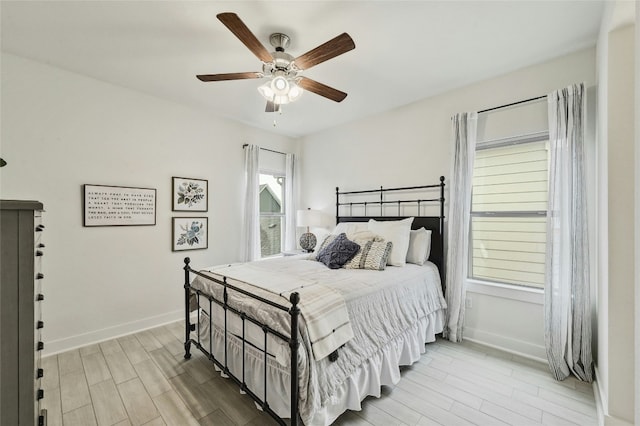 bedroom with multiple windows, light hardwood / wood-style flooring, and ceiling fan