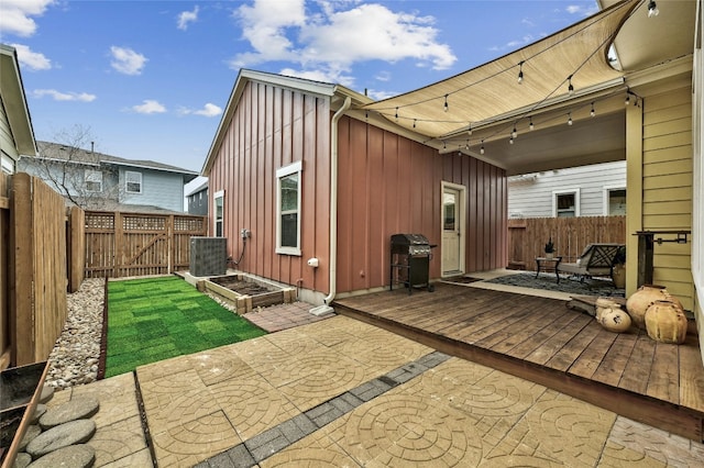 back of property featuring a wooden deck, central AC unit, and a patio