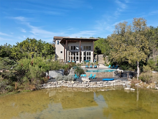 back of property featuring a water view