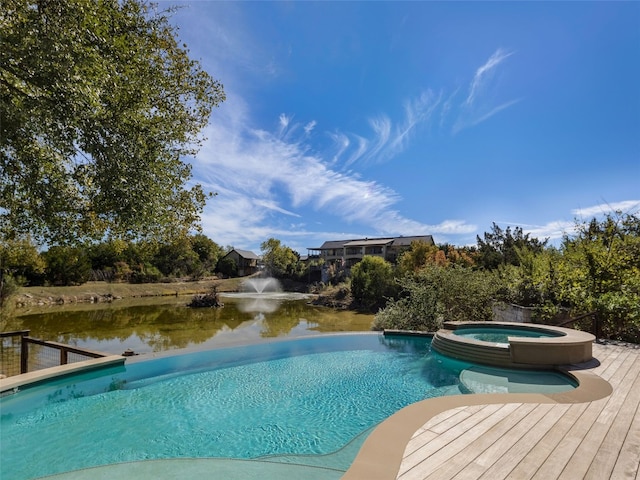 view of pool with an in ground hot tub and a water view