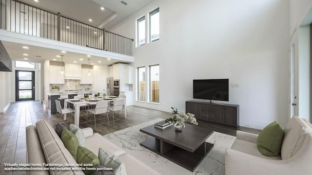 220 La Venta Loop, Liberty Hill, TX 78642 - living area featuring light wood-style floors, a high ceiling, and recessed lighting