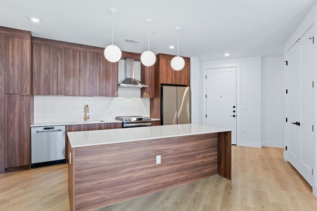 1701 Simond Ave Unit 546, Austin, TX 78723 - kitchen with appliances with stainless steel finishes, wall chimney exhaust hood, a sink, light countertops, and modern cabinets