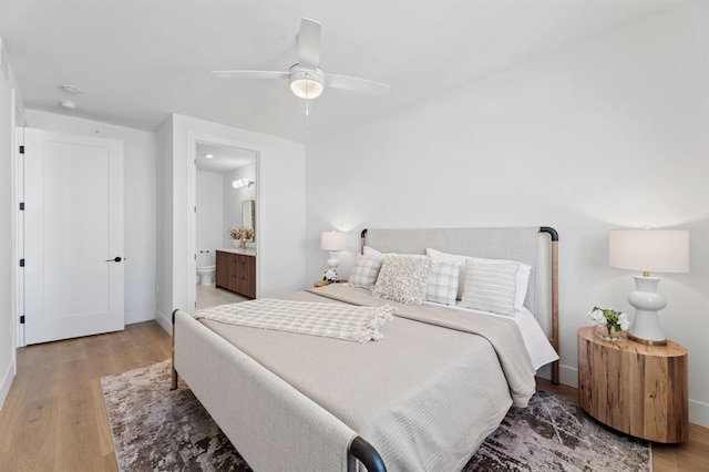 bedroom featuring ceiling fan, ensuite bath, and wood-type flooring