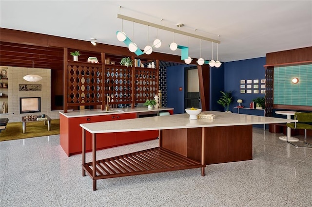 kitchen featuring hanging light fixtures, a center island, sink, and a breakfast bar