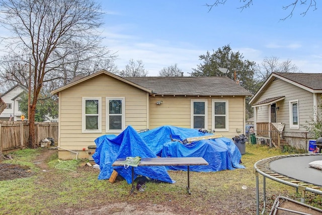 rear view of property with a trampoline