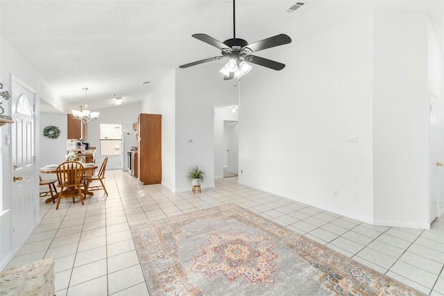 unfurnished living room featuring light tile patterned floors, ceiling fan with notable chandelier, and high vaulted ceiling