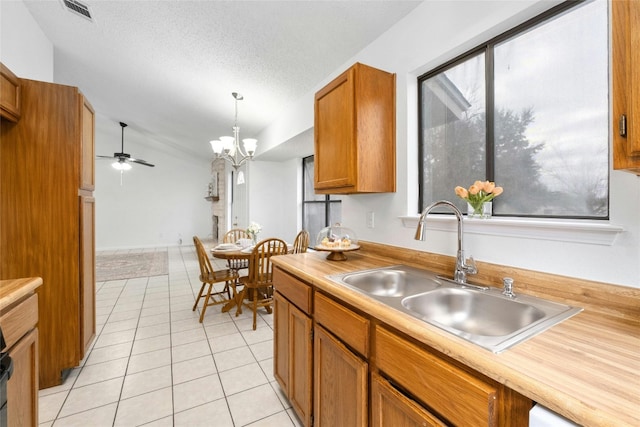 kitchen with sink, decorative light fixtures, a textured ceiling, light tile patterned floors, and ceiling fan with notable chandelier