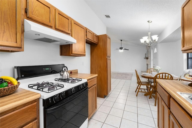 kitchen featuring ceiling fan with notable chandelier, pendant lighting, white range with gas stovetop, light tile patterned floors, and a textured ceiling