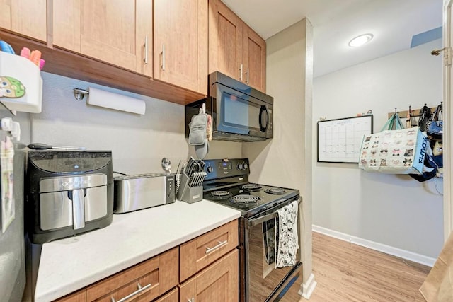 kitchen featuring light hardwood / wood-style flooring and black appliances