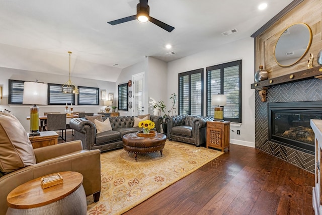 living room with ceiling fan, a fireplace, and dark hardwood / wood-style flooring