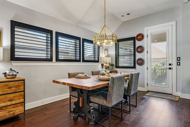 dining space with dark wood-type flooring and a notable chandelier