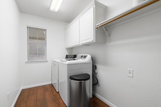 clothes washing area featuring cabinets, dark hardwood / wood-style flooring, and washer and clothes dryer