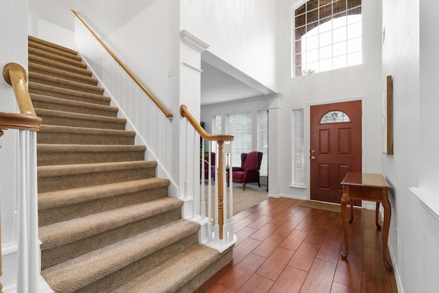 entrance foyer featuring hardwood / wood-style flooring and a towering ceiling