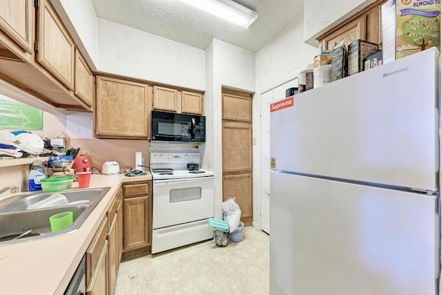 kitchen featuring sink, a textured ceiling, and white appliances