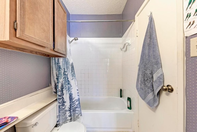 bathroom with toilet, a textured ceiling, and shower / bath combo