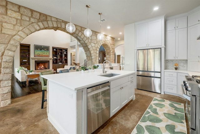 kitchen featuring light countertops, appliances with stainless steel finishes, a sink, and white cabinetry