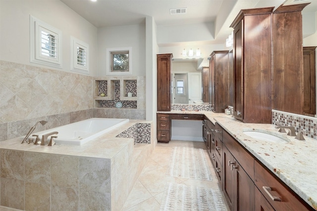 bathroom featuring visible vents, vanity, backsplash, a bath, and tile patterned floors