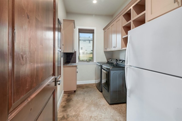 clothes washing area featuring washer and clothes dryer, cabinet space, and baseboards