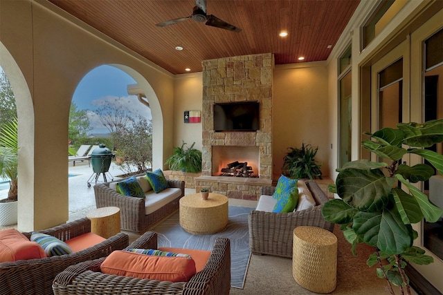 view of patio with an outdoor living space with a fireplace and a ceiling fan