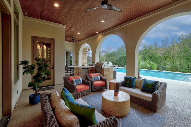 view of patio featuring ceiling fan, an outdoor kitchen, an outdoor living space, and an outdoor pool