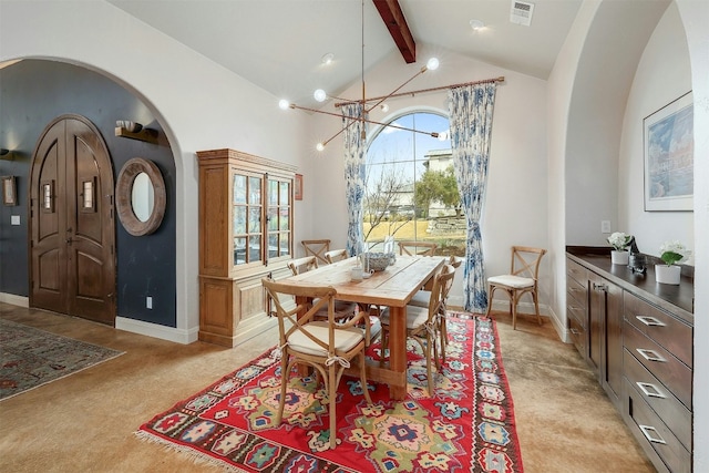 dining area with arched walkways, visible vents, light colored carpet, high vaulted ceiling, and beamed ceiling