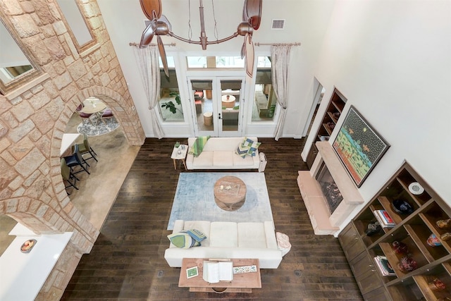 living room with visible vents, dark wood finished floors, and a high ceiling