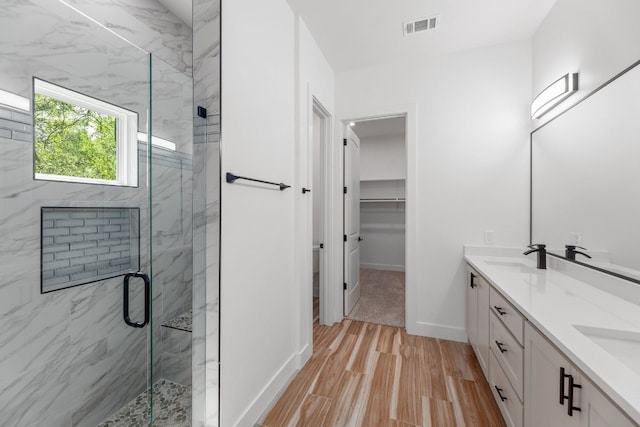 bathroom with an enclosed shower, vanity, and wood-type flooring