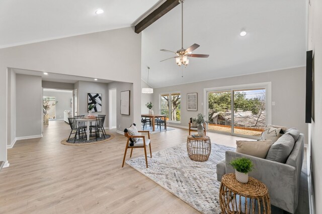 living room with high vaulted ceiling, a ceiling fan, baseboards, light wood-type flooring, and beamed ceiling