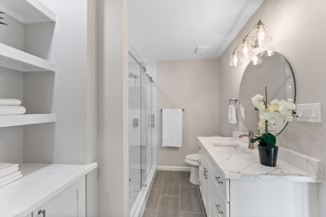 full bathroom featuring a stall shower, baseboards, vanity, and toilet