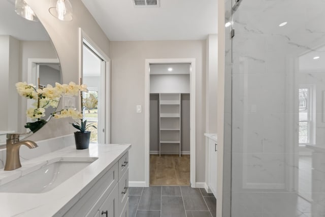 bathroom with vanity and a tile shower