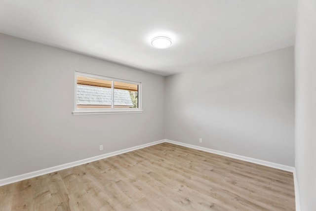 empty room with light wood-style flooring and baseboards