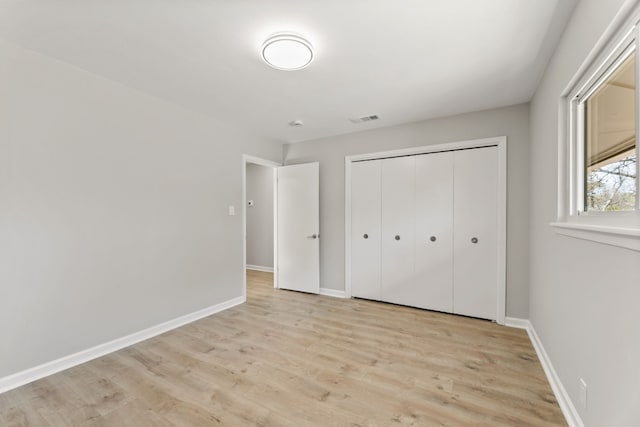 unfurnished bedroom featuring light hardwood / wood-style flooring and a closet