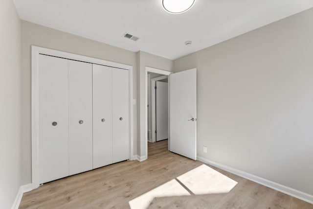 unfurnished bedroom featuring light hardwood / wood-style floors and a closet