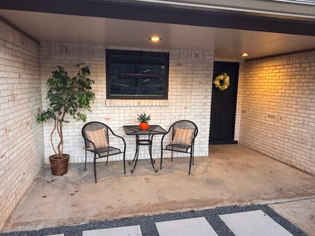 property entrance featuring a patio area and brick siding