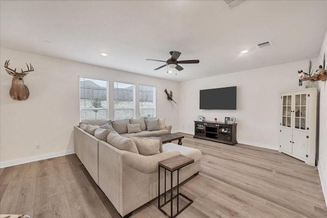 living room with light hardwood / wood-style flooring and ceiling fan