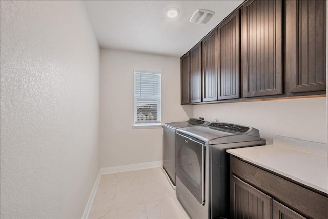 washroom featuring cabinets and separate washer and dryer