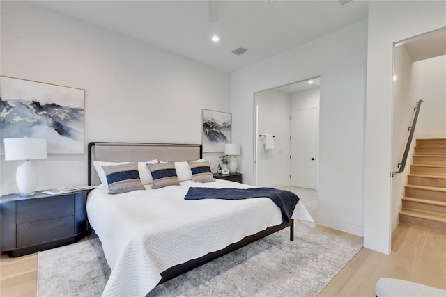 bedroom featuring connected bathroom and light wood-type flooring