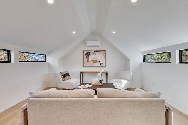 living room featuring lofted ceiling, a wall mounted AC, and light hardwood / wood-style flooring