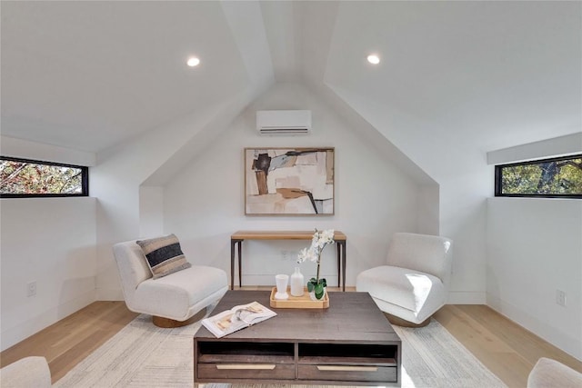 living area with a healthy amount of sunlight, a wall unit AC, and light hardwood / wood-style floors