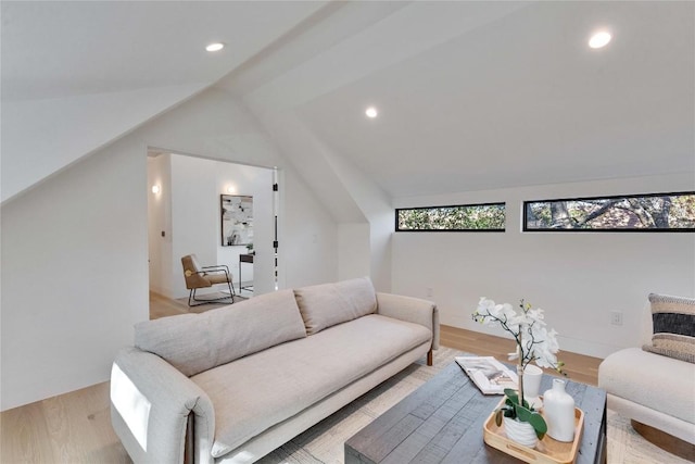 living room featuring light hardwood / wood-style floors and vaulted ceiling