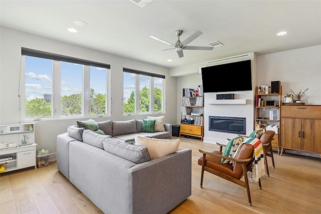 living room with ceiling fan, light hardwood / wood-style floors, and a healthy amount of sunlight