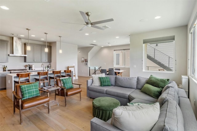 living room with ceiling fan and light wood-type flooring