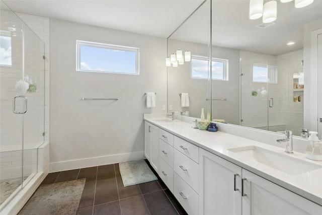 bathroom with vanity, plenty of natural light, tile patterned floors, and walk in shower