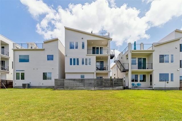 back of house featuring cooling unit and a lawn