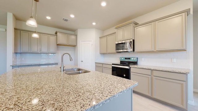 kitchen with light stone countertops, sink, a center island with sink, and range with electric stovetop