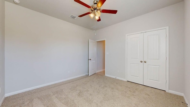 unfurnished bedroom featuring light colored carpet, a closet, and ceiling fan