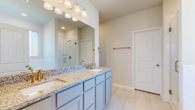 bathroom with vanity, wood-type flooring, and a shower with door